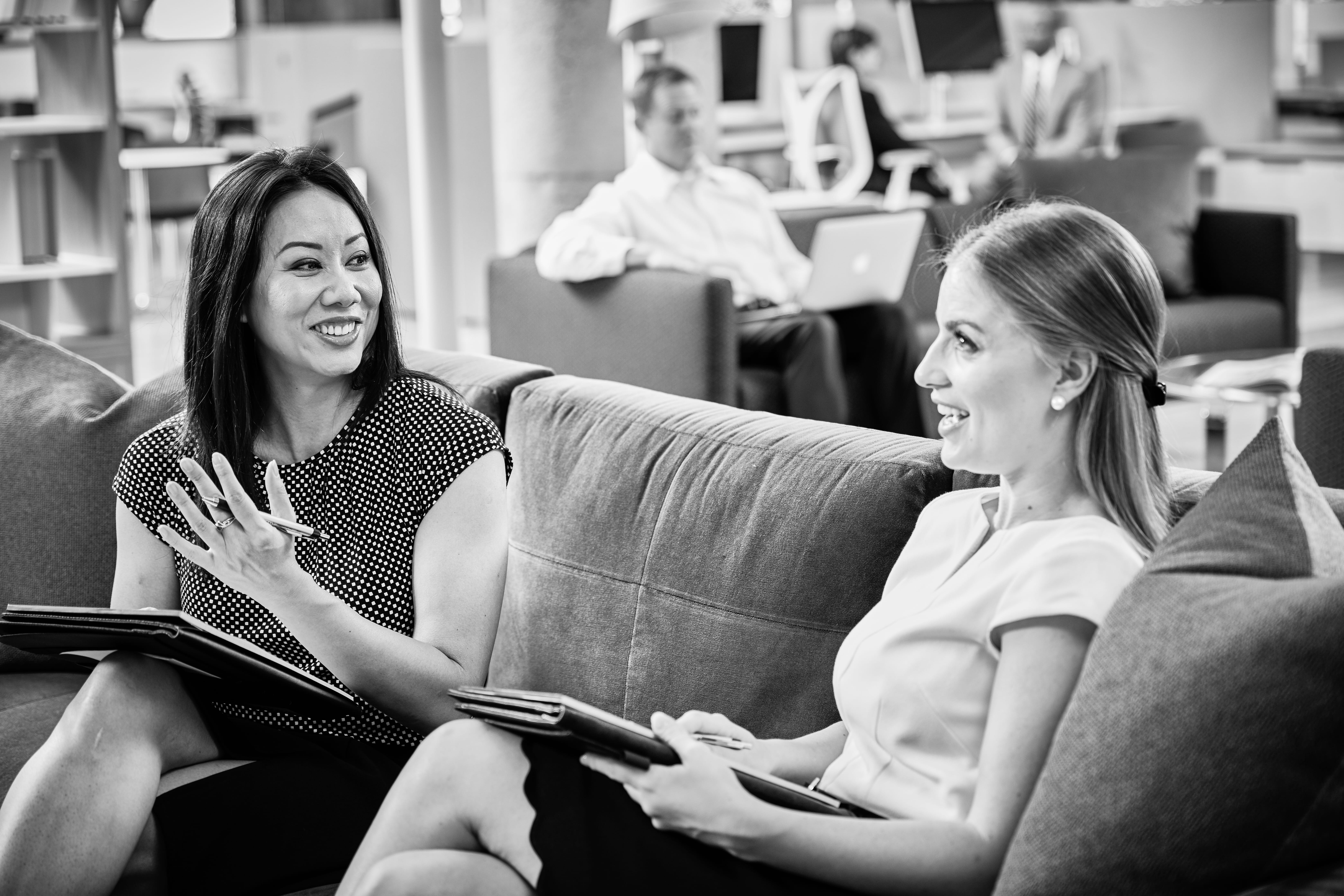 Associates having a conversation while sitting on a couch